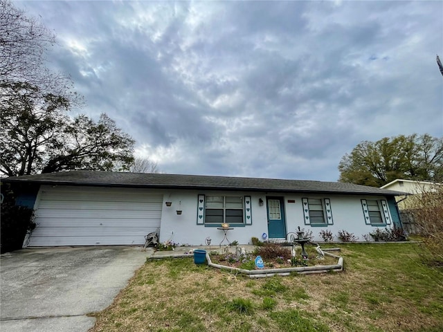 ranch-style home featuring stucco siding, an attached garage, driveway, and a front yard