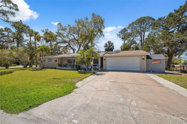 ranch-style house featuring an attached garage, concrete driveway, and a front yard