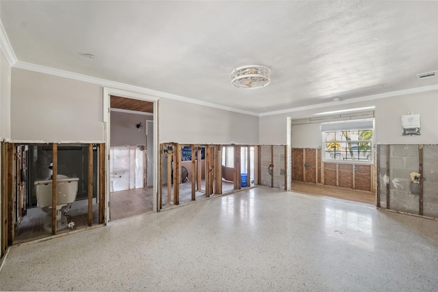 unfurnished room featuring crown molding, visible vents, and speckled floor