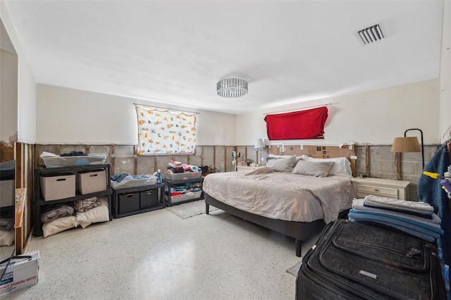 bedroom with visible vents and a wainscoted wall