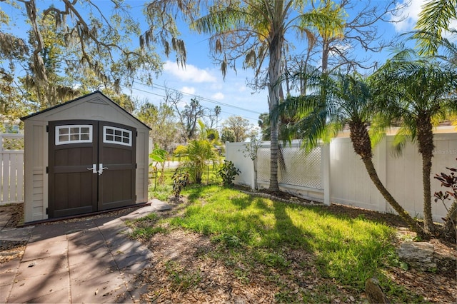 view of yard featuring an outbuilding, a shed, and a fenced backyard