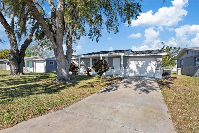 ranch-style home with a front lawn, central AC unit, a garage, and driveway