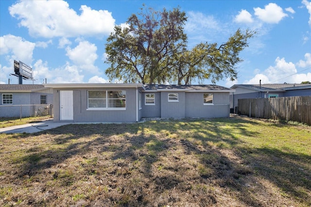 back of property featuring a lawn and a fenced backyard