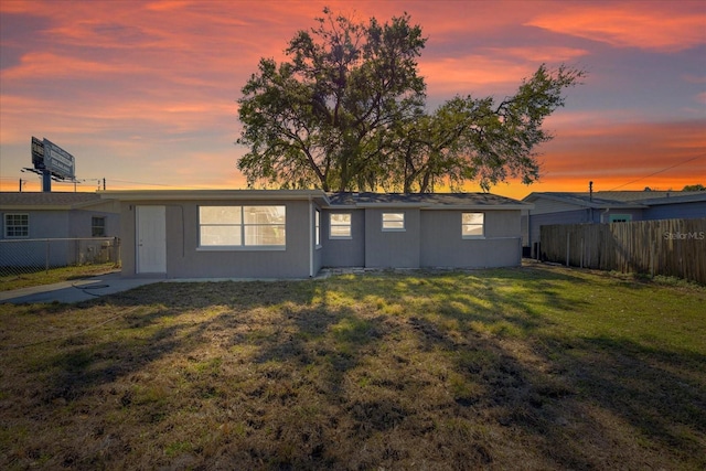 rear view of property with a lawn and fence