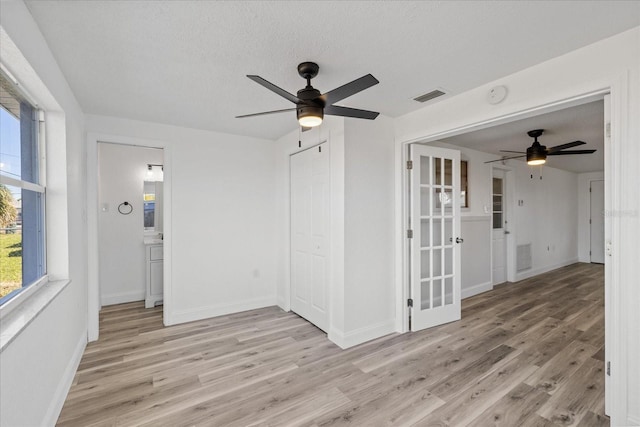 10841 Scenic Dr, Port Richey, FL 34668 - empty room featuring ceiling fan, light wood-style floors, a smoke detector, and a textured ceiling
