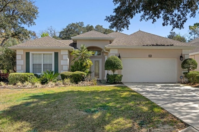 view of front of property featuring stucco siding, driveway, an attached garage, and a front lawn