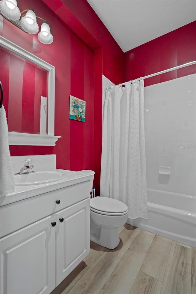 full bath with vanity, toilet, wood finished floors, and shower / bath combo with shower curtain