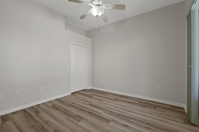 spare room featuring ceiling fan, baseboards, and wood finished floors