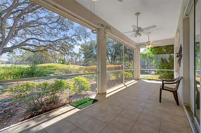 unfurnished sunroom featuring a ceiling fan