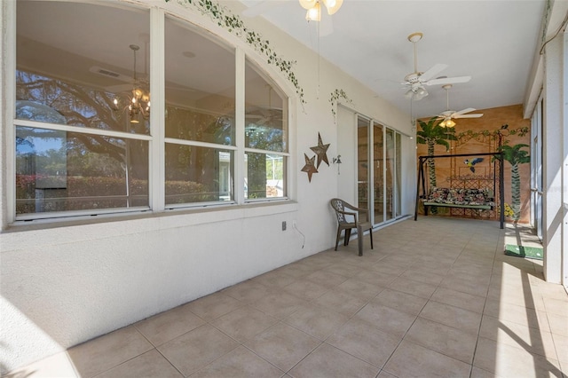 unfurnished sunroom featuring ceiling fan