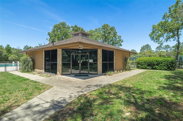 back of property with a lawn, fence, and french doors