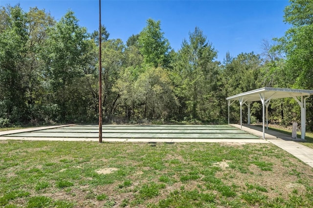 view of property's community with a forest view and a yard