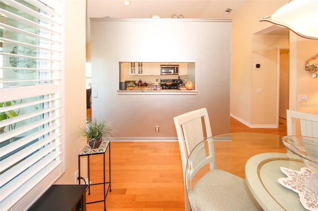 dining space with visible vents, baseboards, and light wood-type flooring