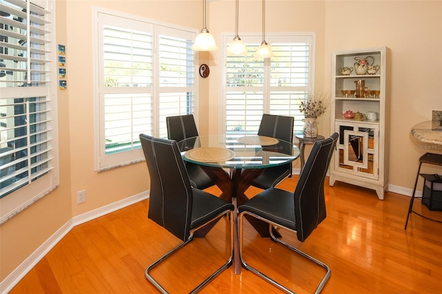 dining area featuring baseboards and light wood-style floors