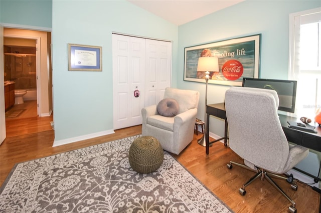 home office featuring lofted ceiling, wood finished floors, and baseboards