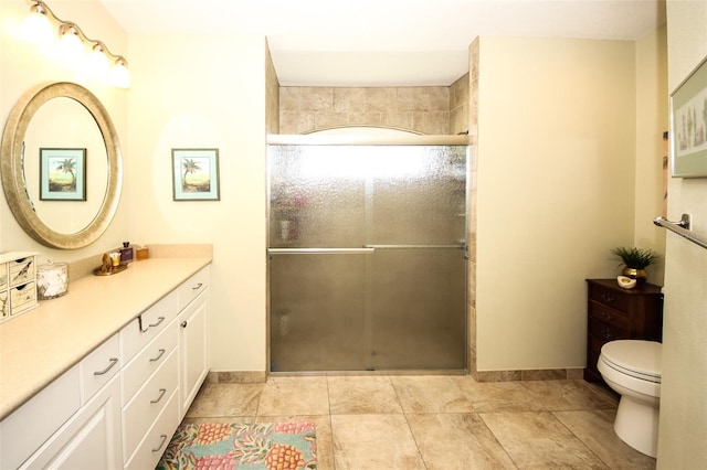 full bath featuring a shower stall, toilet, vanity, and baseboards