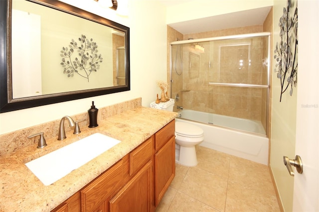 bathroom featuring tile patterned flooring, toilet, vanity, and bath / shower combo with glass door