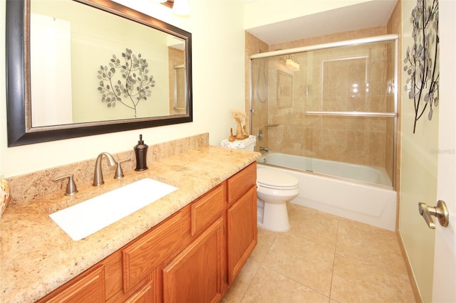 bathroom featuring tile patterned floors, combined bath / shower with glass door, toilet, and vanity