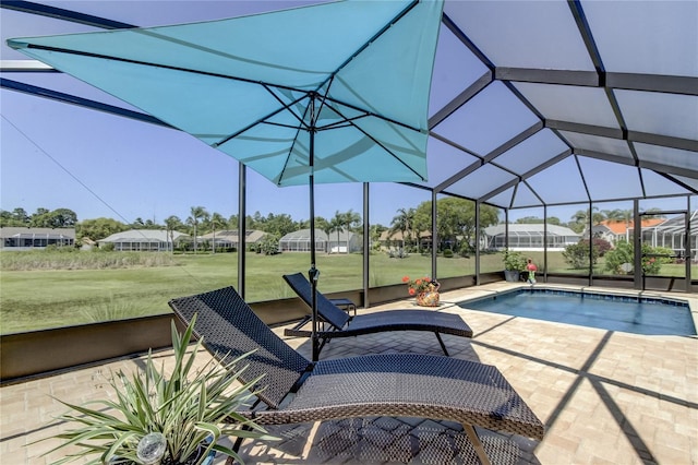 outdoor pool with a lanai, a patio area, and a lawn