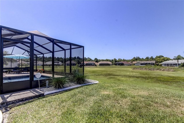 view of yard featuring an outdoor pool, a patio, and a lanai