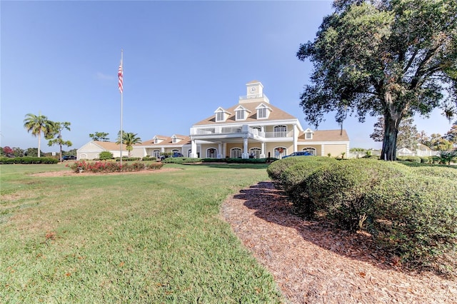 exterior space with a balcony and a front yard