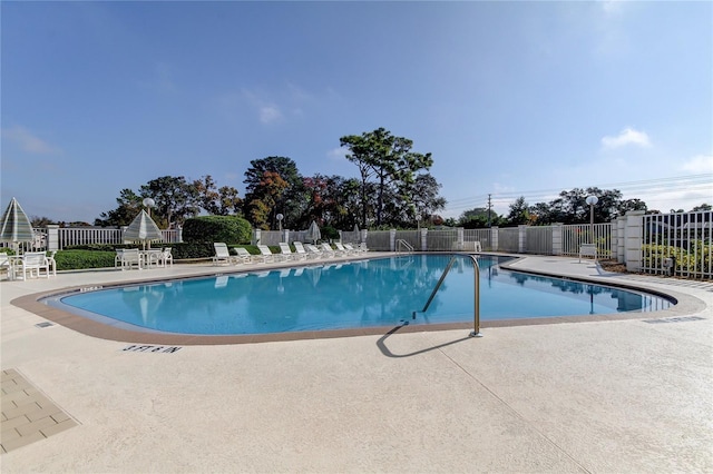 community pool featuring a patio and fence