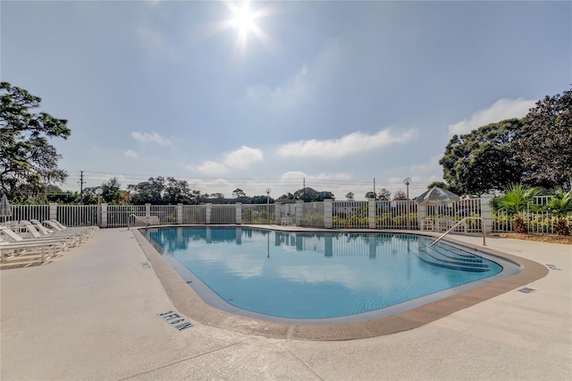 community pool featuring a patio and fence