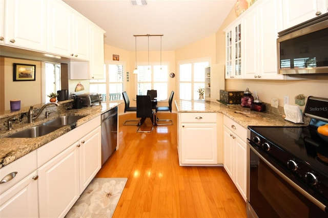 8609 Regal Ln, Hudson, FL 34667 - kitchen with a sink, stainless steel appliances, white cabinetry, light wood-type flooring, and glass insert cabinets