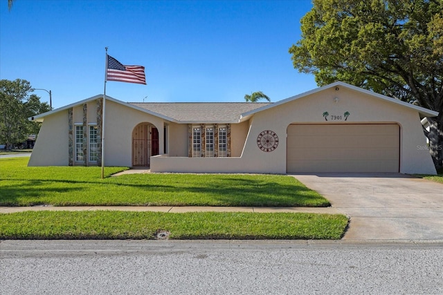 view of front of house featuring a front yard, stucco siding, french doors, driveway, and an attached garage