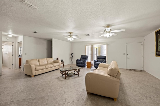 living room with a textured ceiling, visible vents, and ceiling fan