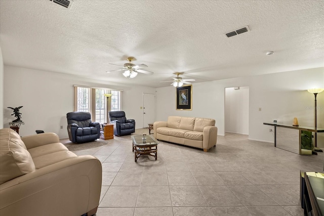 living area with light tile patterned floors, visible vents, a textured ceiling, and ceiling fan