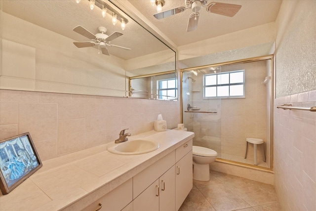 bathroom featuring a shower stall, tile walls, and a ceiling fan