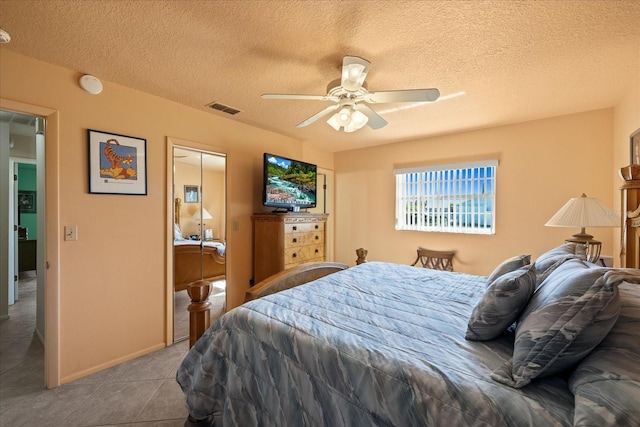 bedroom with visible vents, a textured ceiling, a closet, tile patterned flooring, and ceiling fan