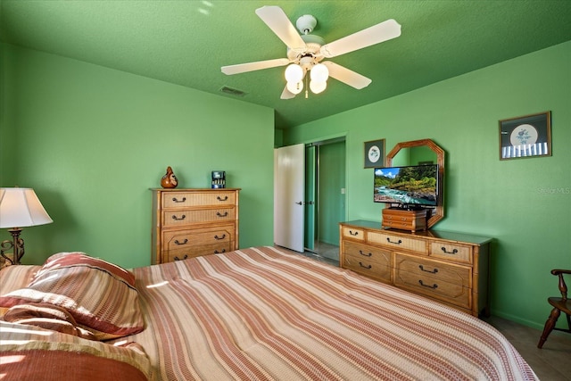 bedroom featuring a closet, visible vents, a textured ceiling, and ceiling fan