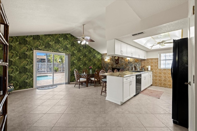 kitchen with visible vents, wallpapered walls, a sink, ceiling fan, and black appliances