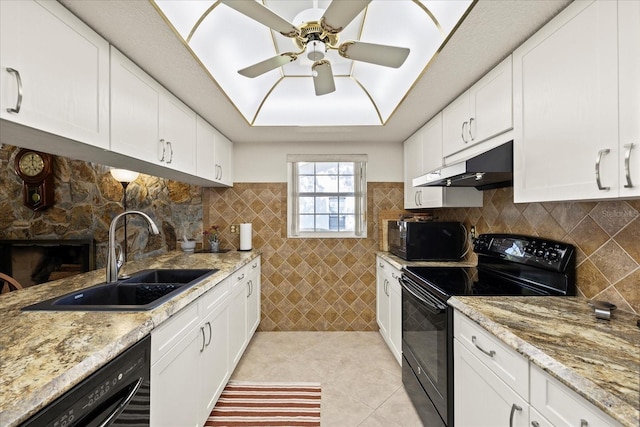 kitchen with black appliances, under cabinet range hood, a sink, white cabinets, and light tile patterned floors