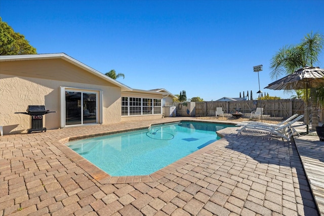 view of pool featuring area for grilling, a patio area, a fenced in pool, and a fenced backyard