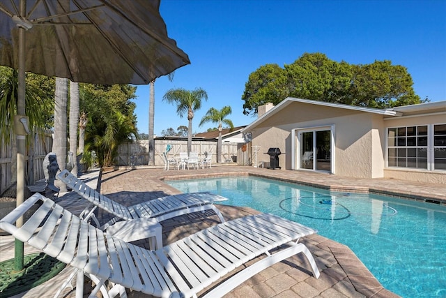 view of pool featuring a fenced backyard, grilling area, a fenced in pool, and a patio