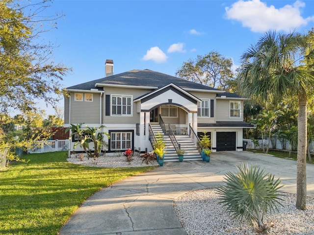 view of front of property with fence, a chimney, stairs, concrete driveway, and a front lawn