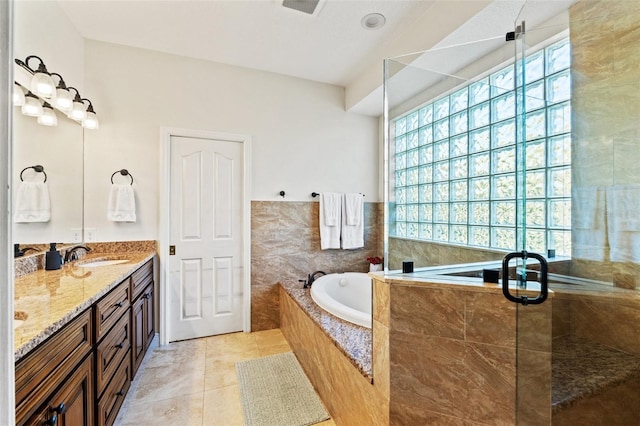 bathroom featuring tile patterned floors, a garden tub, a stall shower, a sink, and double vanity