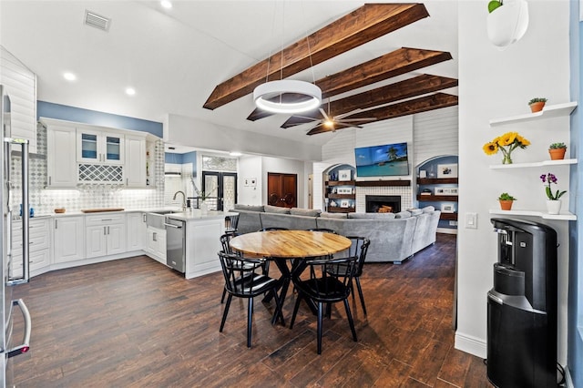 dining space featuring visible vents, dark wood finished floors, recessed lighting, a fireplace, and vaulted ceiling with beams