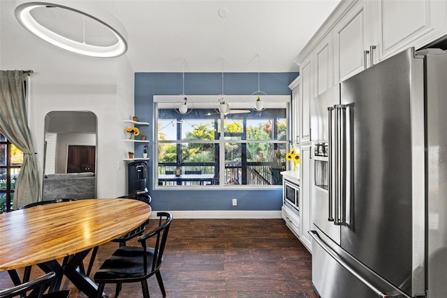 dining space featuring dark wood-style floors and baseboards