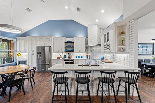 kitchen with open shelves, wall chimney exhaust hood, visible vents, and appliances with stainless steel finishes