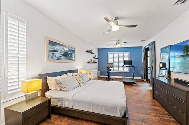 bedroom with dark wood finished floors, baseboards, visible vents, and ceiling fan