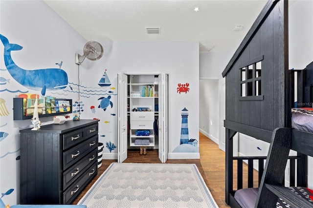 bedroom featuring baseboards, visible vents, and dark wood-style flooring