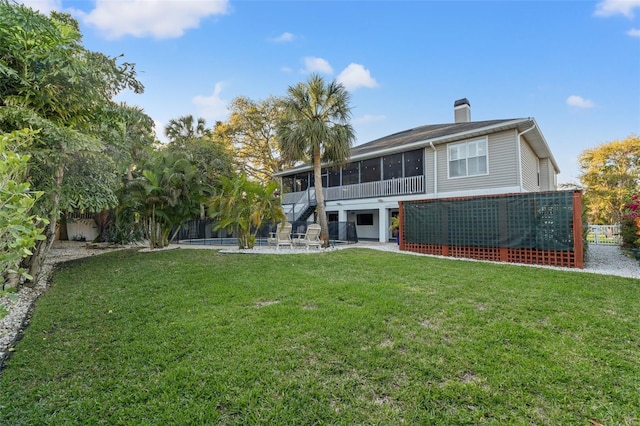 back of property featuring fence, stairs, a lawn, a sunroom, and a patio area