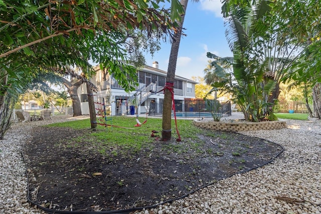 view of property's community featuring stairs, a swimming pool, and a fenced backyard