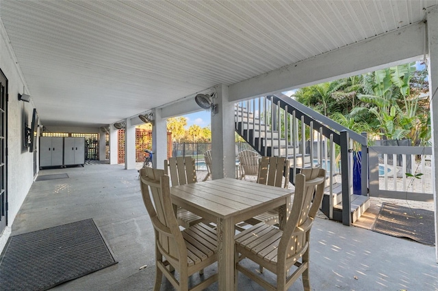 view of patio with stairs, outdoor dining space, and fence