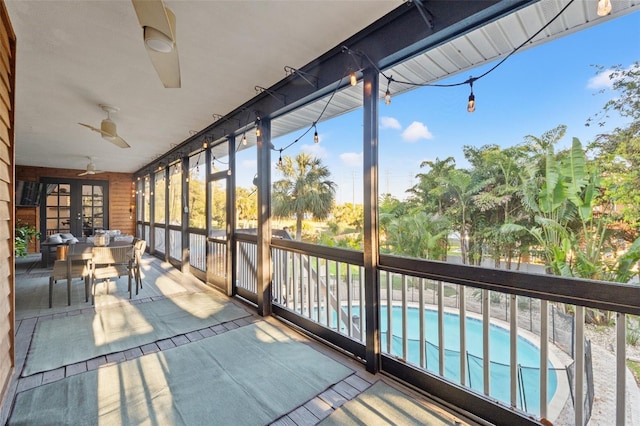 unfurnished sunroom featuring a ceiling fan