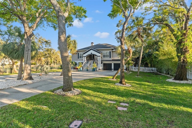 coastal inspired home with a garage, driveway, a chimney, and a front lawn